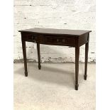 A Regency style mahogany serpentine side table, the cross banded top with reeded edge over two