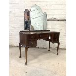 A mahogany serpentine dressing table, circa 1930's, the back with three shaped and bevelled swing