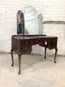 A mahogany serpentine dressing table, circa 1930's, the back with three shaped and bevelled swing