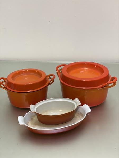 Doufeu Cousances, set of two large cast iron orange enamelled casserole dishes (largest: 15cm x d.