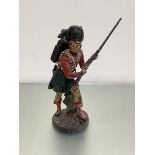 A cast iron doorstop style figure of a Scots Highlander, painted with polychrome enamels (sword a/f)