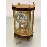 An Edwardian ormolu four glass mantel clock with enamel dial with visible escapement, with arabic