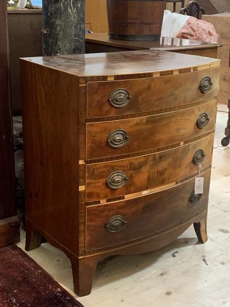 A 19th century cross banded mahogany bow front chest with four graduated drawers on splayed