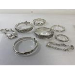 A collection of five inscribed silver bangles (largest: 6cm x 5.5cm) (combined: 88g), a white
