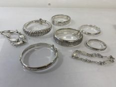 A collection of five inscribed silver bangles (largest: 6cm x 5.5cm) (combined: 88g), a white