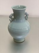 A modern Chinese celadon ware baluster vase with fish scroll handles to side (h.26cm)