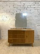 Meredew, A mid century light oak veneered dresseing chest with swing mirror, three drawers and a