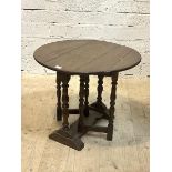 A 19thc gate leg occasional table the oak oval top on turned supports on trestle base H53cm,