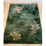 A Chinese washed wool carpet, the green field with floral motifs, 350cm x 247cm