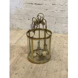 A cylindrical brass and glass four branch hanging lantern with chain and ceiling rose, H64cm D35cm