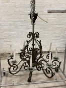 An early 20th century French patinated wrought metal chandelier, the hammered copper boss in the