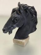 A cast bronze sculpture of a horse's head in Roman style, on alabaster base (23cm x 20cm)