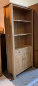 A contemporary light oak open bookcase, with two adjustable shelves over drawer and cupboard, H185cm