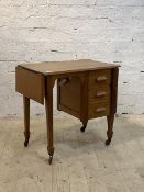 An early to mid 20th century walnut desk, with drop leaf, three drawers, raised on square tapered