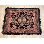 A woven wall hanging or rug, with medallion on black field of cartouche form enclosed by floral '