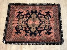 A woven wall hanging or rug, with medallion on black field of cartouche form enclosed by floral '