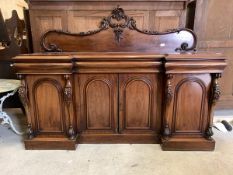 A Victorian mahogany inverted break front sideboard, with scrolled ledge back over moulded top, four