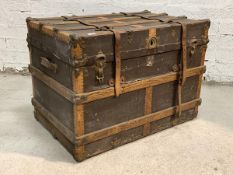 A Large early 20th century metal and wood bound steamer trunk, with leather carry handle to each