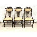 A Set of three late Victorian side chairs, the pierced crest rails and splats over upholstered
