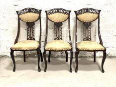 A Set of three late Victorian side chairs, the pierced crest rails and splats over upholstered