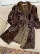 A fur coat measures 34cm across the shoulders x 105cm, single pocket to interior