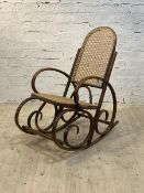 An early to mid 20th century bentwood rocking chair with cane seat and back panel, H103cm, W55cm,