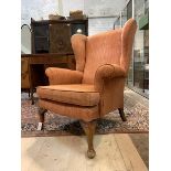 A Georgian style wingback chair, upholstered, raised on cabriole supports, H96cm, W80cm, D73cm