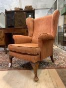 A Georgian style wingback chair, upholstered, raised on cabriole supports, H96cm, W80cm, D73cm