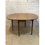 A mid century drop leaf dining table, the oval top raised on turned tapered supports, H73cm, 108cm x