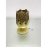 A Monart glass tulip shaped lamp with pyrites, scrolling coloured glass etc., on circular moulded