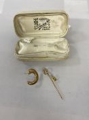 A C shaped earring, post marked 375, post back marked 18k, a yellow metal stick pin with horseshoe