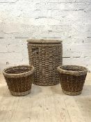 A Large cylindrical lidded wicker basket, containing a quantity of logs (H60cm) together with a pair