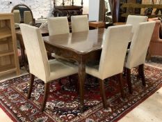 A French style dining suite, comprising an extending dining table with serpentine top raised on