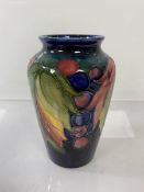 A Moorcroft vase of fruit and leaf design, partial label and signatures to base, potter to M. The