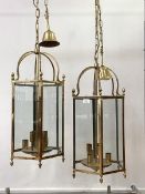 A pair of brass hexagonal hanging lanterns, each with inset glass panels, six branches, chair and