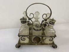An Epns condiment stand set with three decanters, a glass salt and pepper with metal tops, a