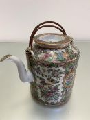 An early 20thc Chinese Canton famille rose teapot complete with circular top and scrolling spout and