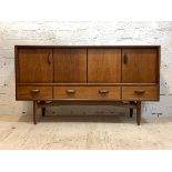 G-Plan, a mid century teak sideboard, with two folding doors each enclosing a shelf, over three