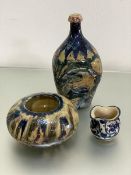 A pottery crush sided bottle style vase decorated with blue, green and red incised floral and bird