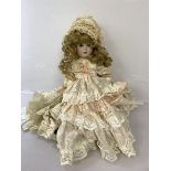 A Scottish china doll in lace dress inscribed Kyla Kraft, Scotland to back of neck, with parasol (