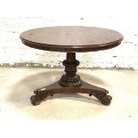 A Mid 19th century mahogany centre table, the circular moulded tilt top raised on leaf carved