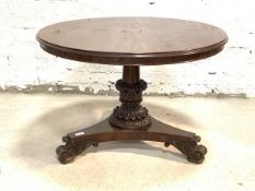 A Mid 19th century mahogany centre table, the circular moulded tilt top raised on leaf carved