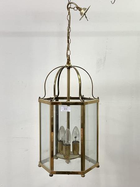 A brass hexagonal hanging lantern, with inset glass panels, six branches, chair and ceiling rose,