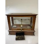 An Edwardian glazed case set of mahogany apothecary scales, label inscribed Goodbrand & Co Ltd,
