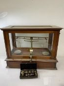 An Edwardian glazed case set of mahogany apothecary scales, label inscribed Goodbrand & Co Ltd,