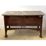 An Art Nouveau period mahogany wash stand, the marble top over twin carved panelled doors, raised on