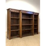 A late Victorian oak breakfront bookcase, the moulded top over nine adjustable shelves, framed