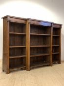 A late Victorian oak breakfront bookcase, the moulded top over nine adjustable shelves, framed