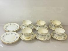 A set of six teacups with winter leaf and fruit decoration, inscribed Fine Bone China under crown to