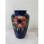 A Moorcroft vase, floral decoration with blue ground, (h 16cm)